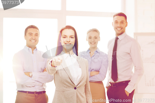 Image of businesswoman in office pointing finger at you