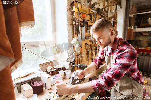 Image of carpenter working with plane and wood at workshop