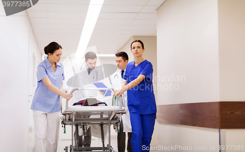 Image of medics with woman on hospital gurney at emergency