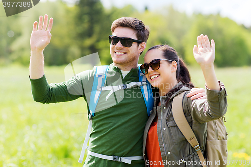 Image of happy couple with backpacks hiking outdoors