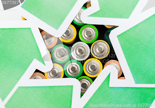 Image of close up of batteries and green recycling symbol