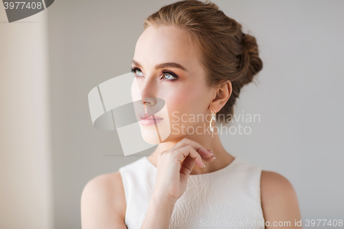 Image of smiling woman in white dress with diamond jewelry