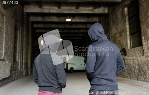 Image of addict men or criminals in hoodies on street