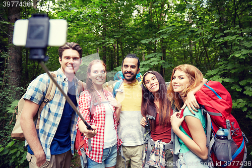 Image of friends with backpack taking selfie by smartphone