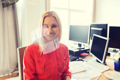 Image of happy creative female office worker with computers