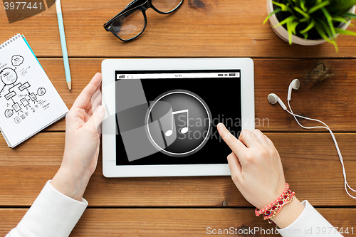 Image of close up of woman with tablet pc on wooden table