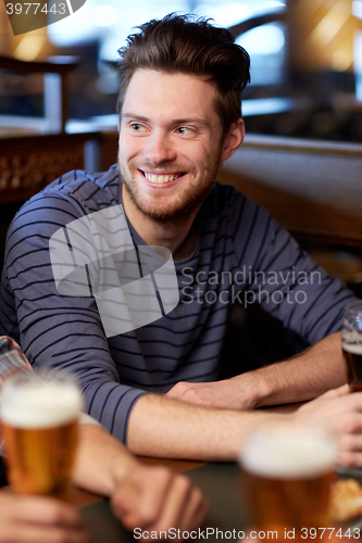 Image of happy male friends drinking beer at bar or pub