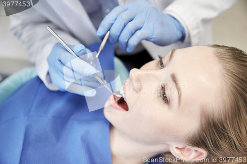 Image of close up of dentist checking female patient teeth