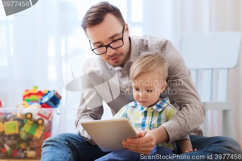 Image of father and son with tablet pc playing at home