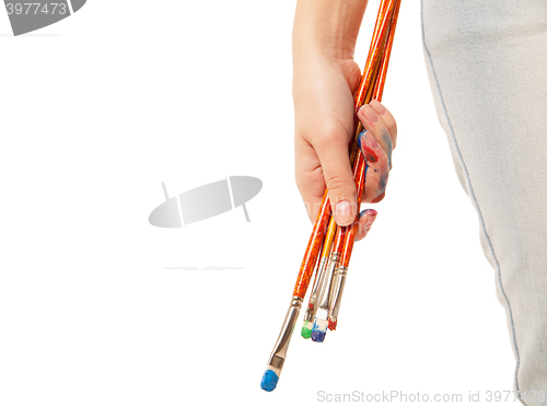 Image of Hand holding brushes isolated on white