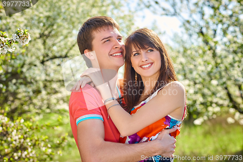 Image of Young couple enjoying in blooming garden