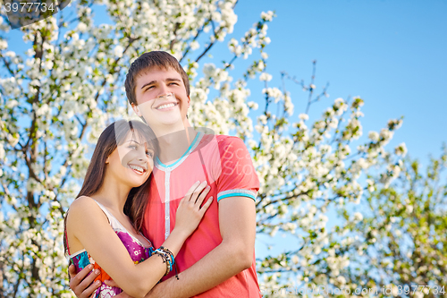 Image of Young couple enjoying in blooming garden