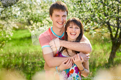 Image of Young couple enjoying in blooming garden