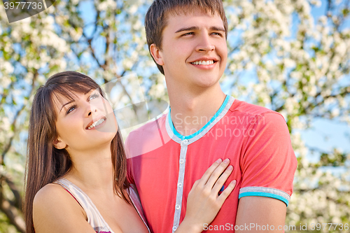 Image of Young couple enjoying in blooming garden