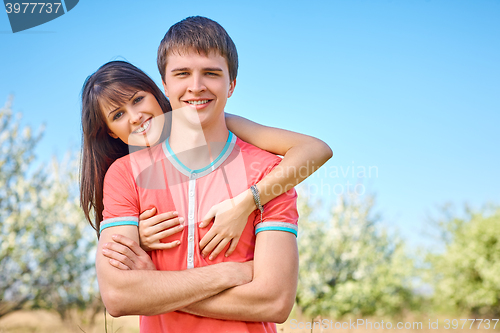 Image of Young couple enjoying in blooming garden