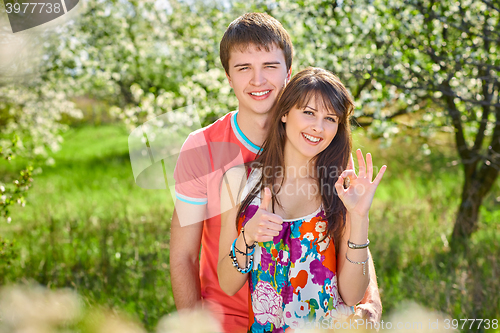 Image of Young couple enjoying in blooming garden