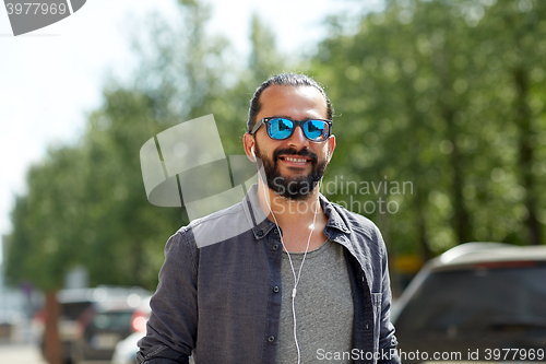 Image of man with earphones listening to music in city