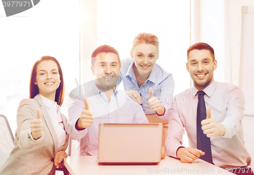 Image of business team working with laptop in office