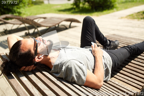 Image of man with earphones and smartphone listening music