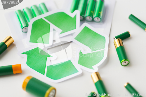 Image of close up of batteries and green recycling symbol