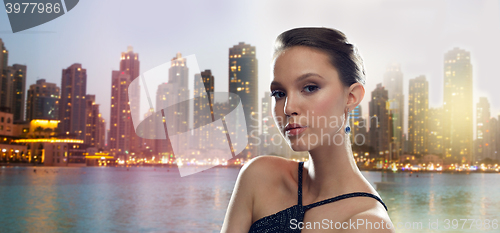 Image of beautiful young asian woman with earring in city