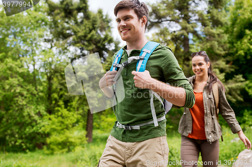 Image of happy couple with backpacks hiking outdoors