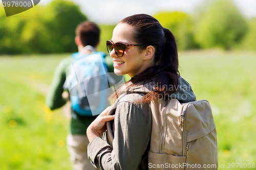 Image of happy couple with backpacks hiking outdoors