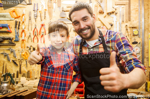 Image of father and little son making thumbs up at workshop