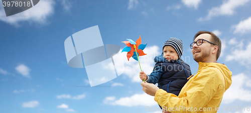 Image of happy father and son with pinwheel toy outdoors