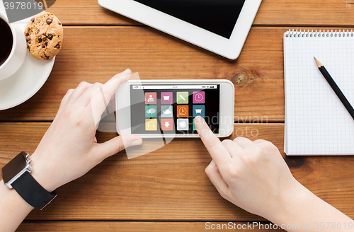 Image of close up of woman with smartphone on wooden table