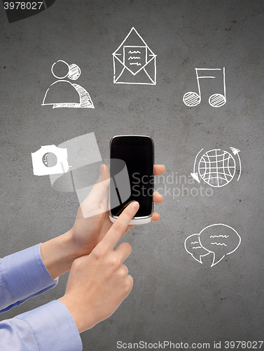 Image of close up of hands with smartphone and doodles