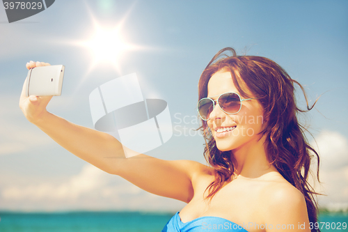 Image of woman in bikini with phone