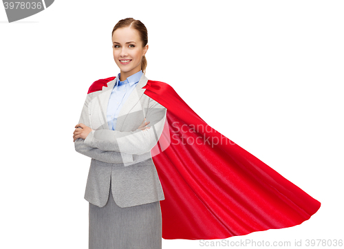Image of young smiling businesswoman in red superhero cape