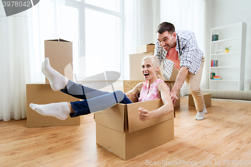 Image of couple with cardboard boxes having fun at new home