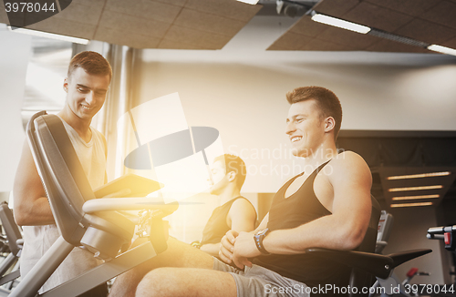 Image of men exercising on gym machine