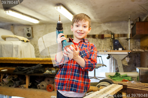 Image of happy little boy with drill at workshop