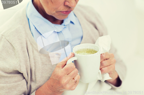 Image of close up of sick senior woman drinking tea at home