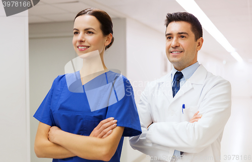 Image of smiling doctor in white coat and nurse at hospital