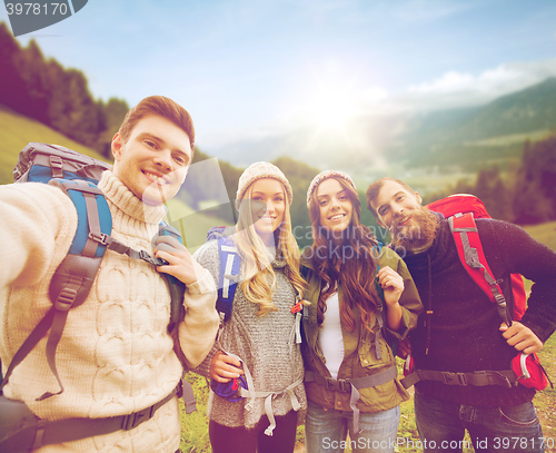 Image of group of smiling friends with backpacks hiking