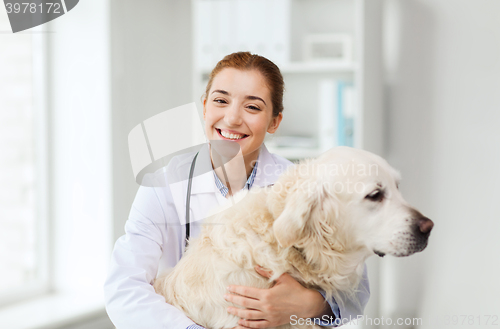 Image of happy doctor with retriever dog at vet clinic