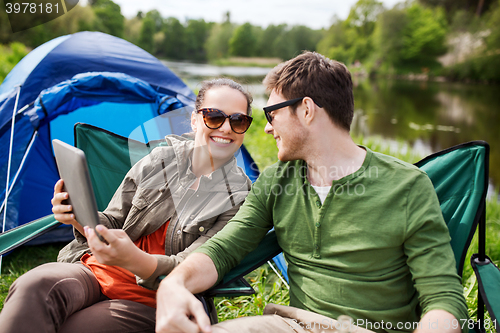 Image of happy couple with tablet pc at camping tent