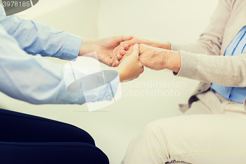 Image of close up of senior and young woman hands