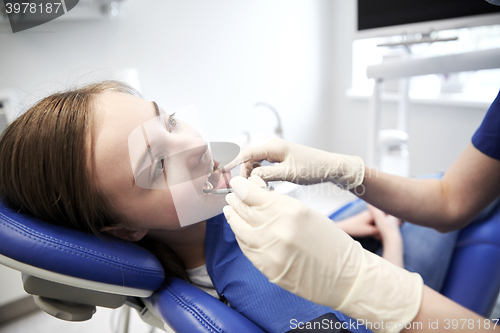 Image of female dentist checking patient girl teeth