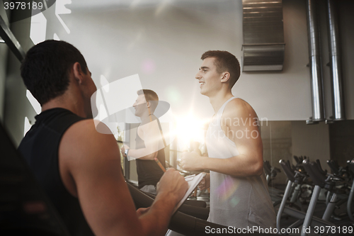 Image of men exercising on treadmill in gym