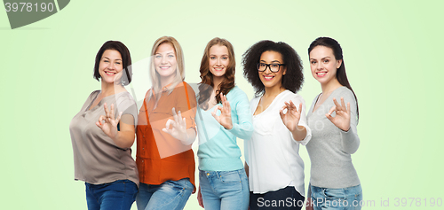 Image of group of happy different size women showing ok