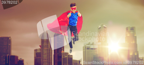 Image of boy in superhero cape and mask showing thumbs up