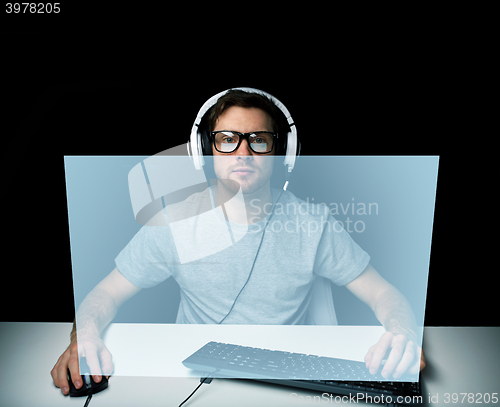 Image of man in headset playing computer video game
