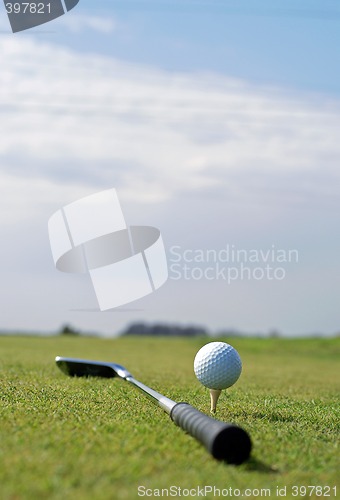 Image of Golf ball in tall green grass set against blue sky
