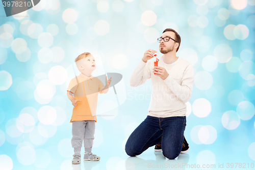 Image of father with son blowing bubbles and having fun