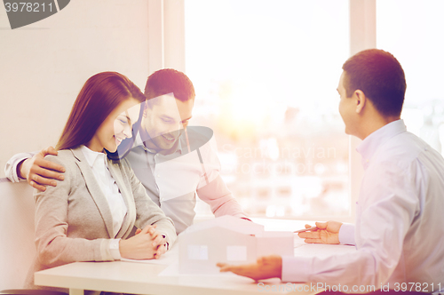 Image of couple looking at model of their house at office